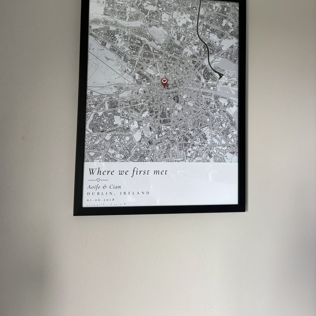 Framed custom map print hanging on a plain wall