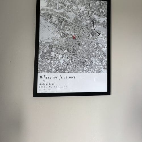Framed custom map print hanging on a plain wall