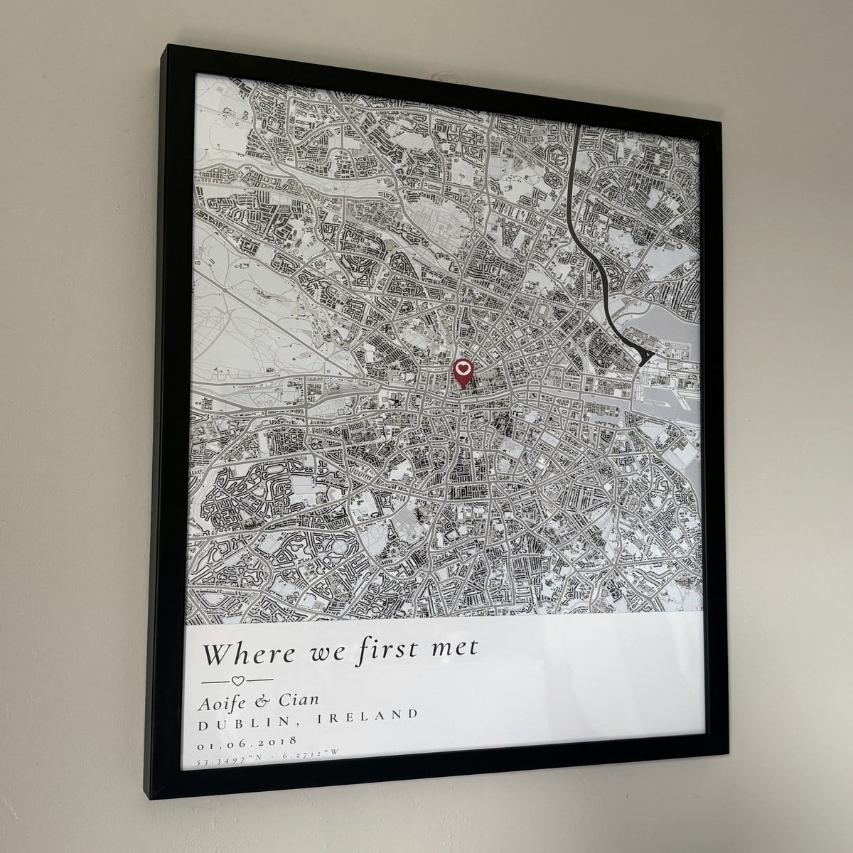 Custom map poster on a wall, angled view showing the black frame